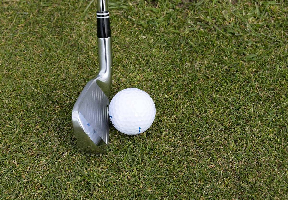 An iron and golf ball on the fairway