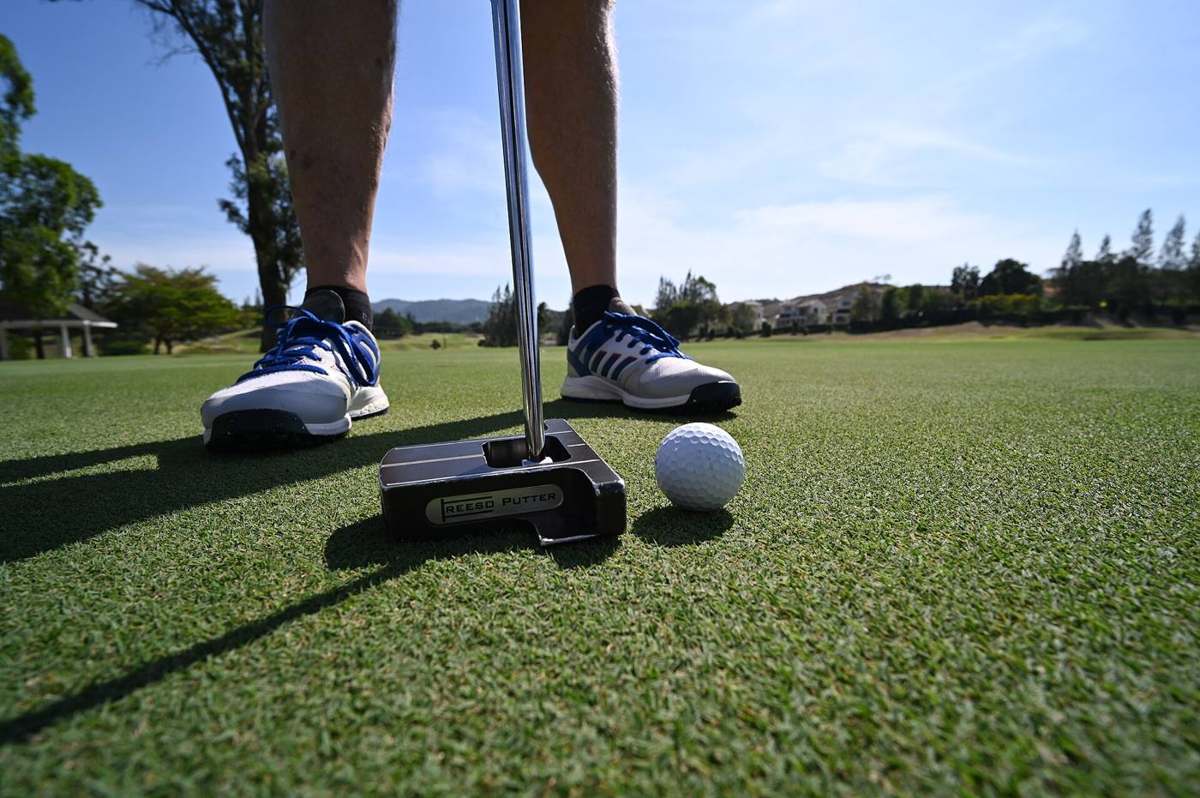 DZ6 2506 Ready to sink the putt focus stance and a steady hand on the green